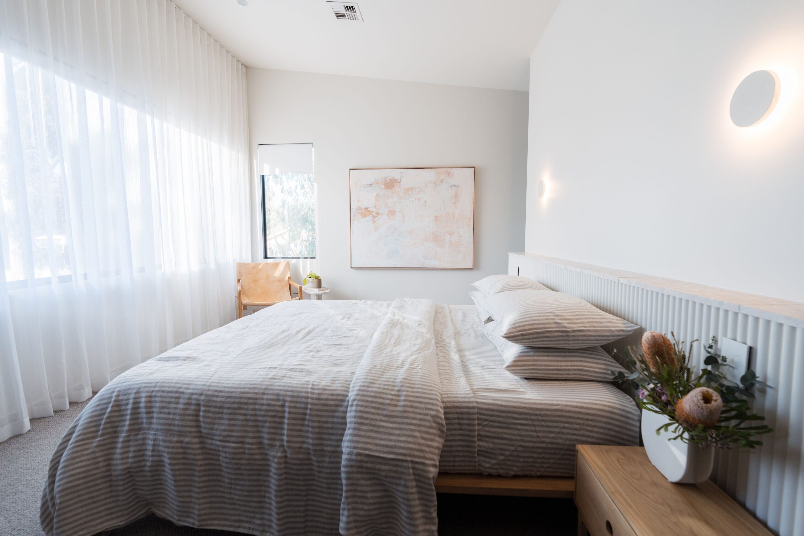 White Sheer Curtains with Blockout Roller Blinds layered underneath in a bedroom