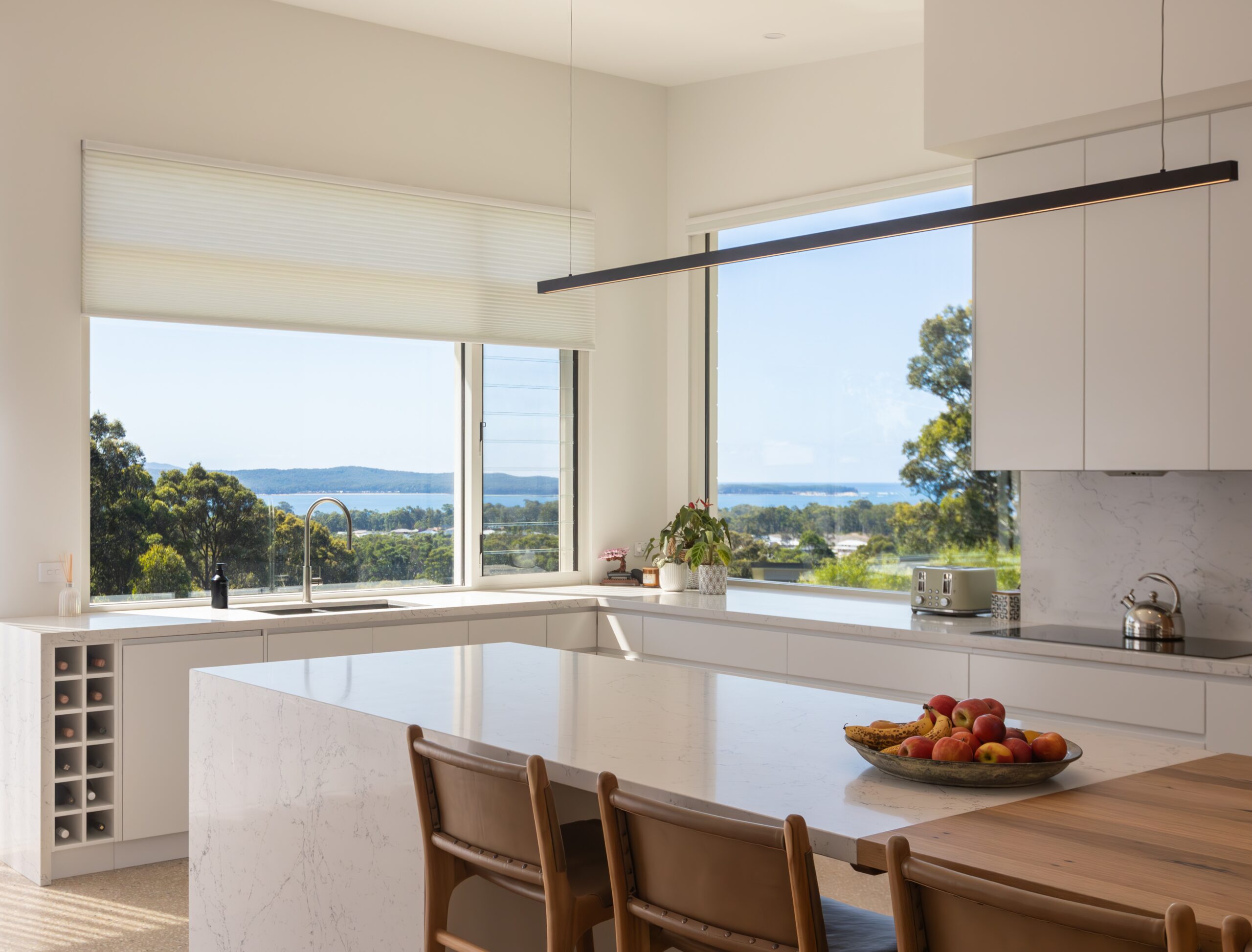 Neutral coloured Cellular Blinds opened in a kitchen with a seaview through the window