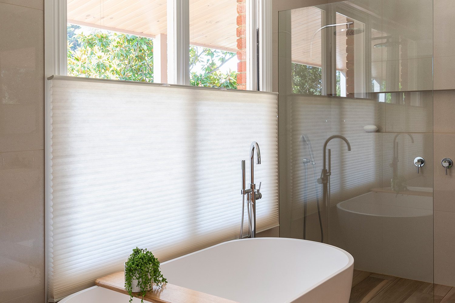 Neutral coloured Cellular Blinds providing privacy in a bathroom next to bath
